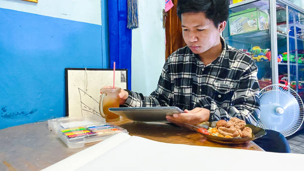 young men using tablet computer doing homework